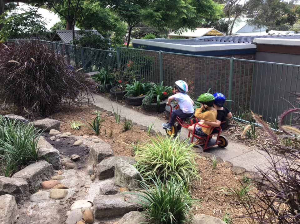 Children riding bikes along the garden path