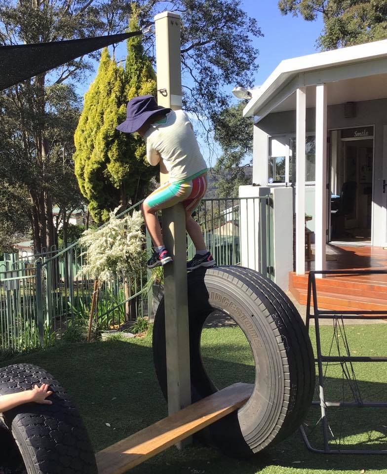 A child climbing a pole in the playground