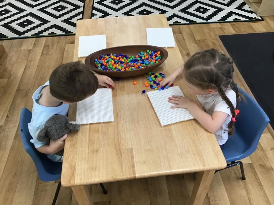 Two children drawing at a table