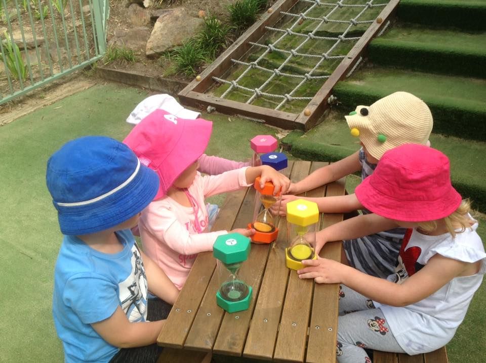 Children playing with sand timers
