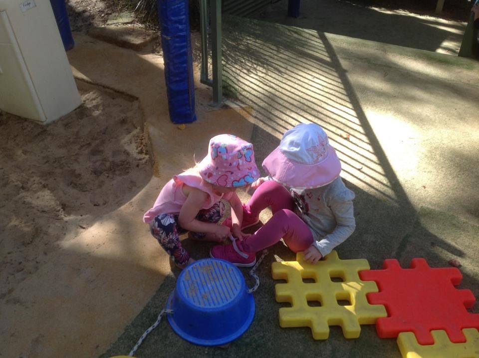 Two children playing together in the sandpit